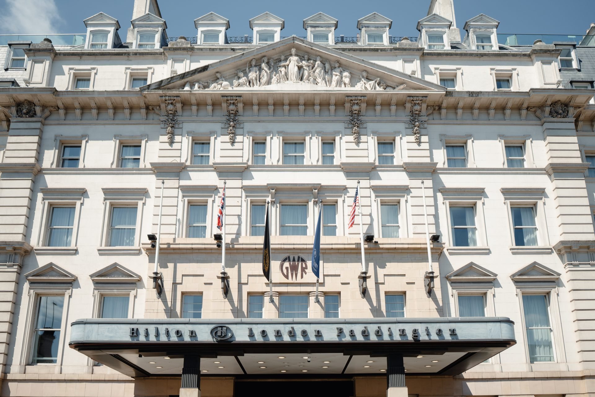 Hilton London Paddington Victorian facade with statuary, flags and the GWR shield above the entrance